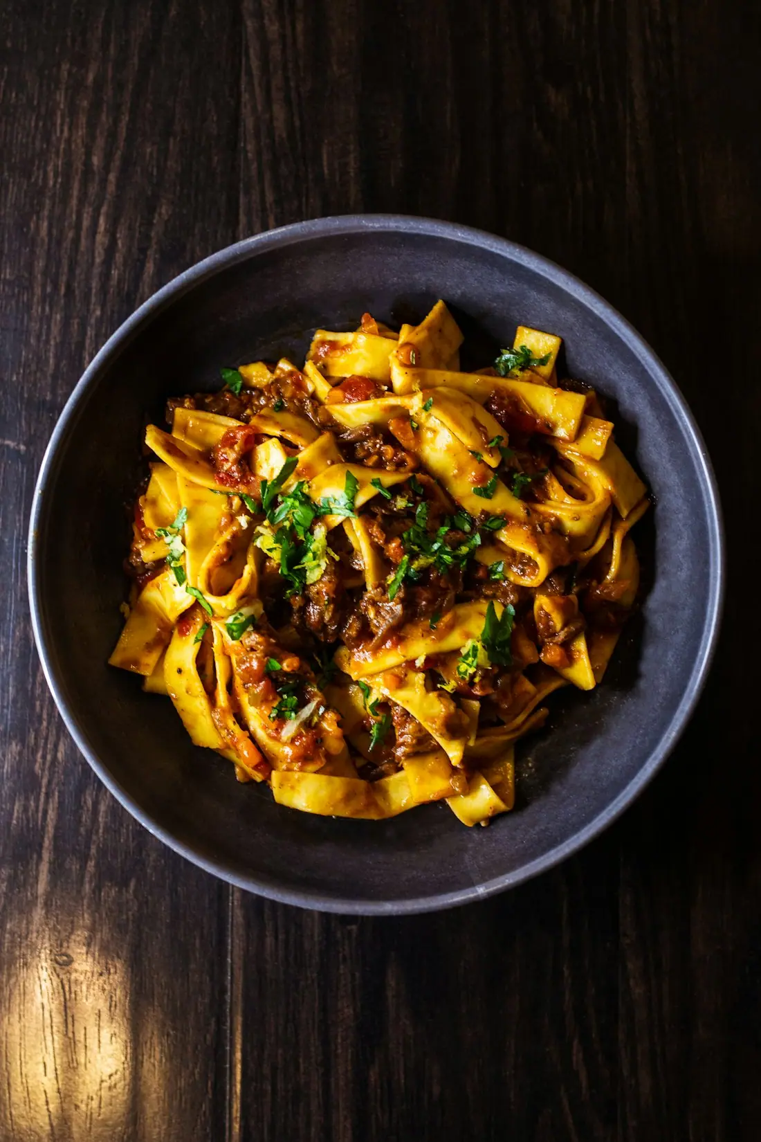 Pasta mit Ragù in einer dunklen Schale